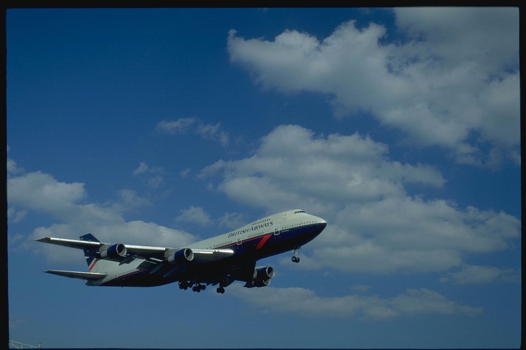Парящая железная птица British Airways прорезывает атлантические облака летя в Нью-Йорк