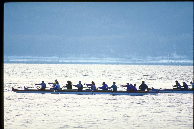 Viajes de grupo en el río en canoa de seis. A principios de agua de plata de la luz del sol