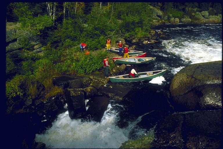 Речной водопад прерывает путешествие по горной реке на каноэ