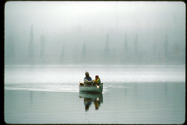 Плавание по озеру на каноэ в туманный осенний день