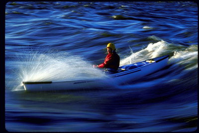 По синим волнам реки плывёт человек в белом каноэ