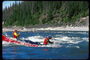 Rameurs dans leur kayak aviron à contre-courant d\'une rivière de montagne