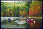 Descendant dans le canot pendant le début de l\'automne. Maple feuilles rougissent sur la rive