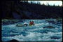 Фотография девственного леса окружающего горную реку и смелых любителей плавания на каяке