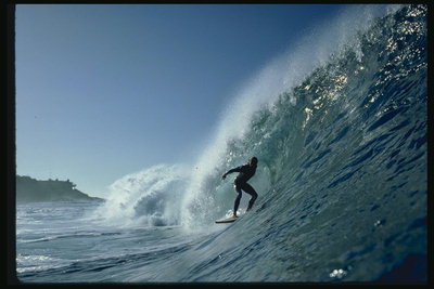 Фотография горы из волны, надвигающейся на серфингиста