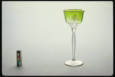 Sticla pe un peduncul lung subţire de sticlă verde de nuante