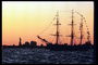 Корабль в порту Нью-Йорке на фоне статуи свободы и вечернего заката