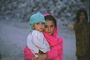 Дівчинка в рожевому шарфи з хлопчиком на руках
