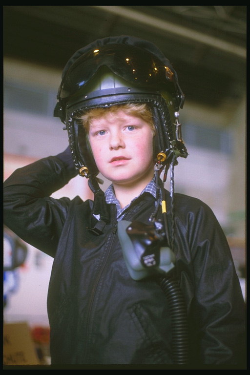 O rapaz, no capacete de piloto