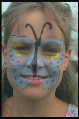 Метелик фарбою на обличчі у дівчинки