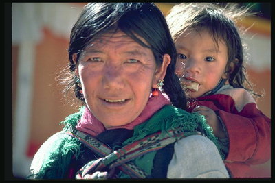 O femeie cu un copil în spatele