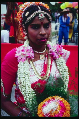 امرأة في فستان الزفاف مع باقة من الزهور حول عنقه